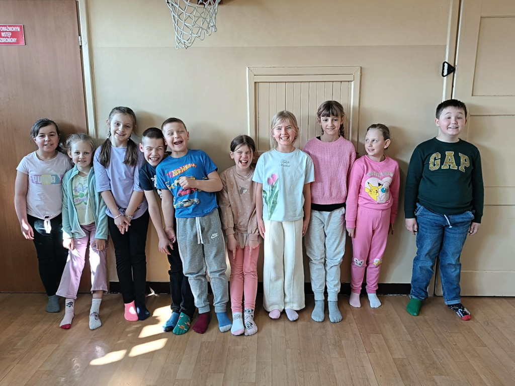 Uczniowie w klasie prezentują kolorowe skarpety nie do pary.